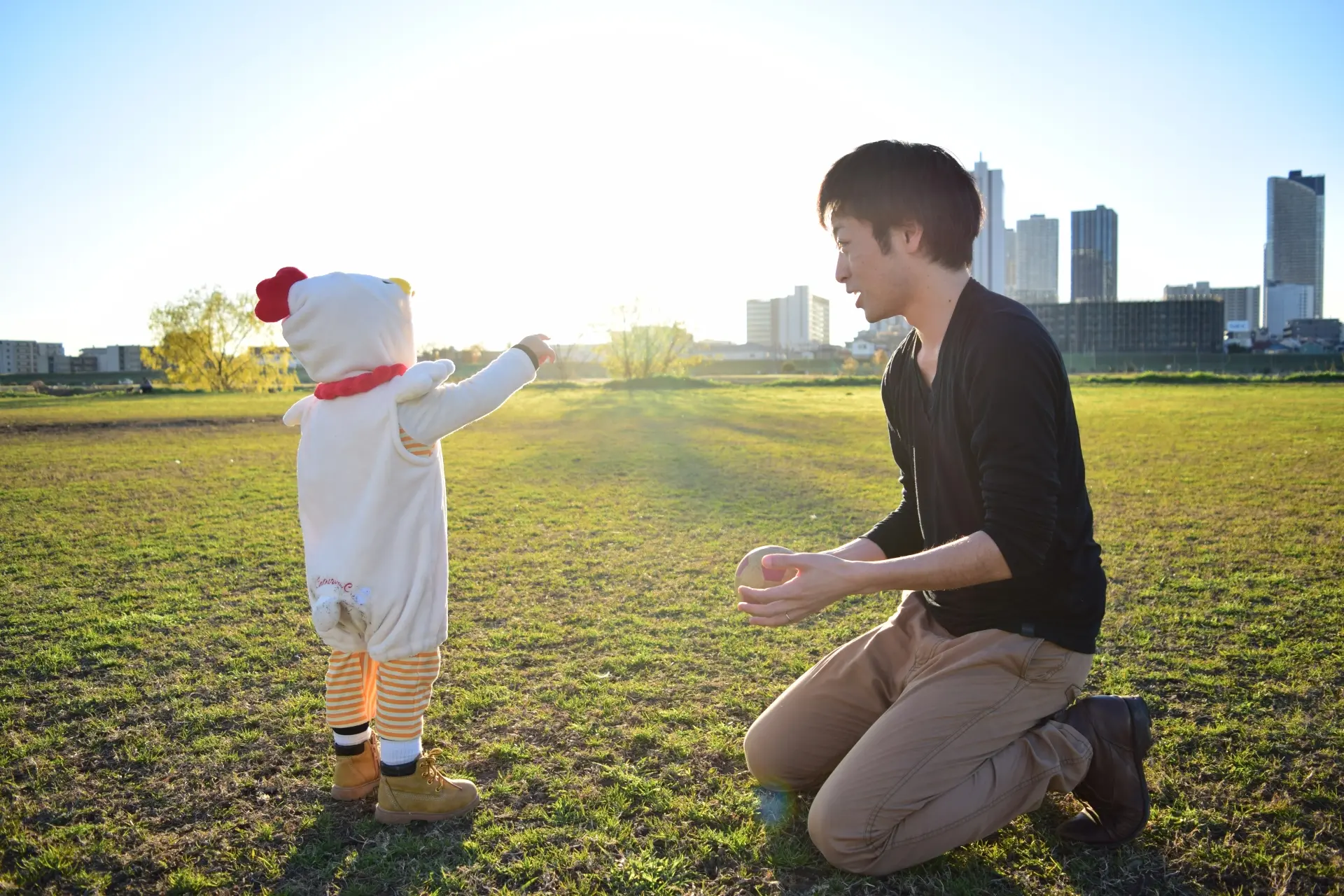 原っぱで遊ぶ親と子